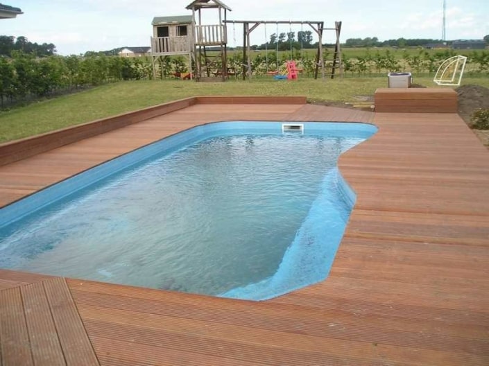 Udendørs pool i haven med legeplads i baggrunden